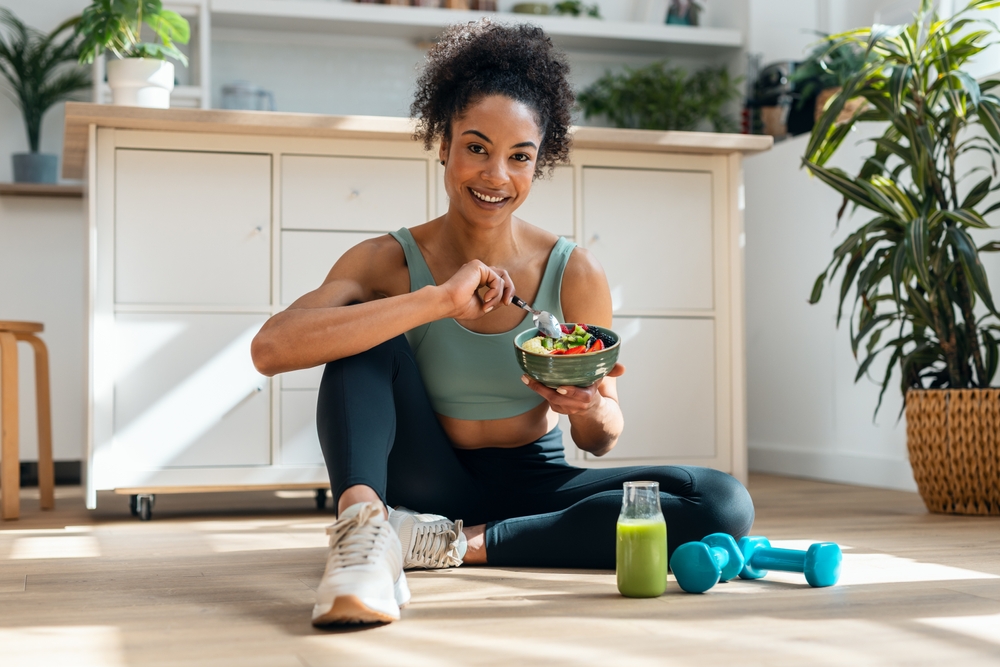 Shot,Of,Athletic,Woman,Eating,A,Healthy,Fruit,Bowl,While