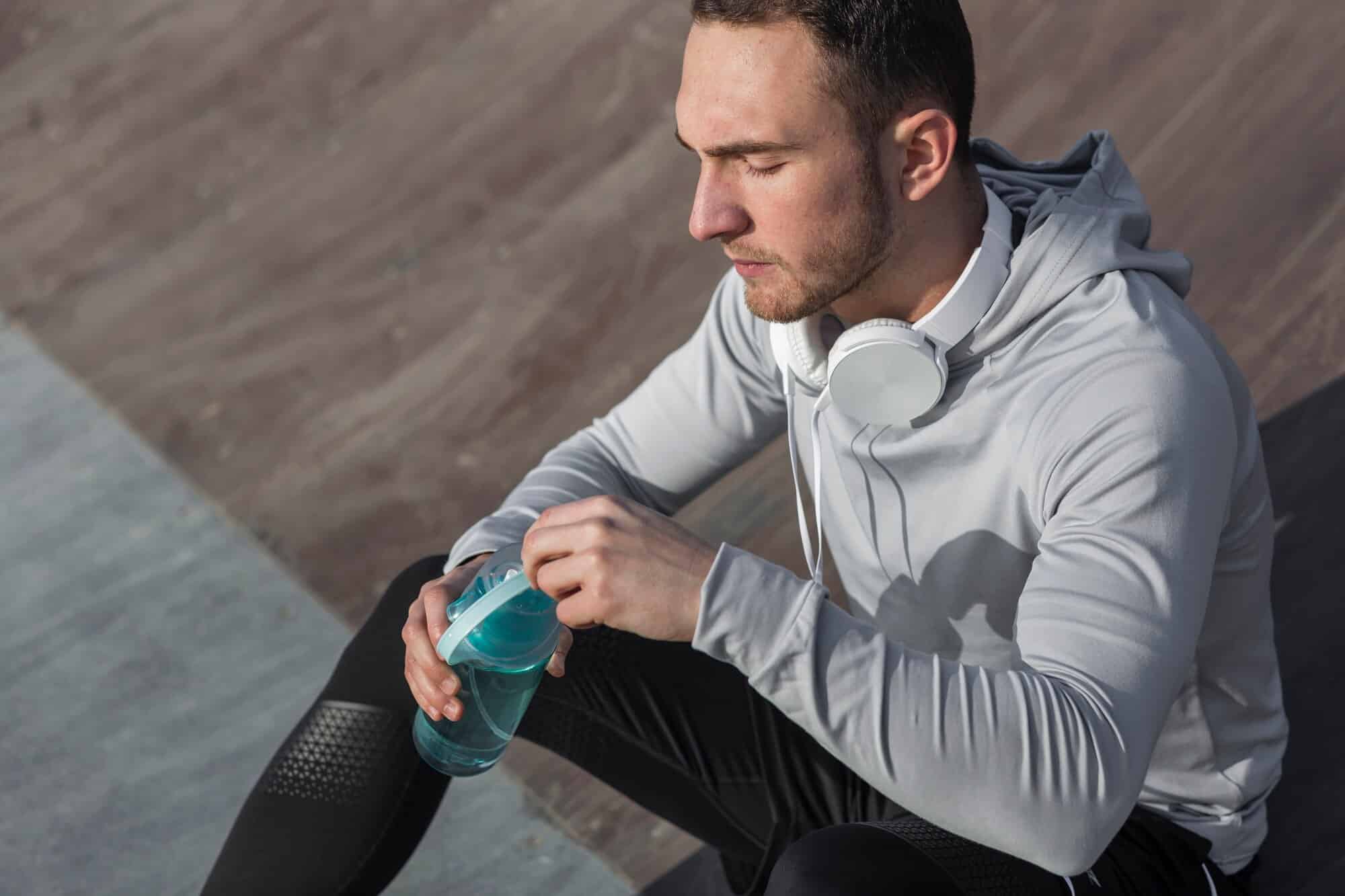 man with eyes closed and water bottle image