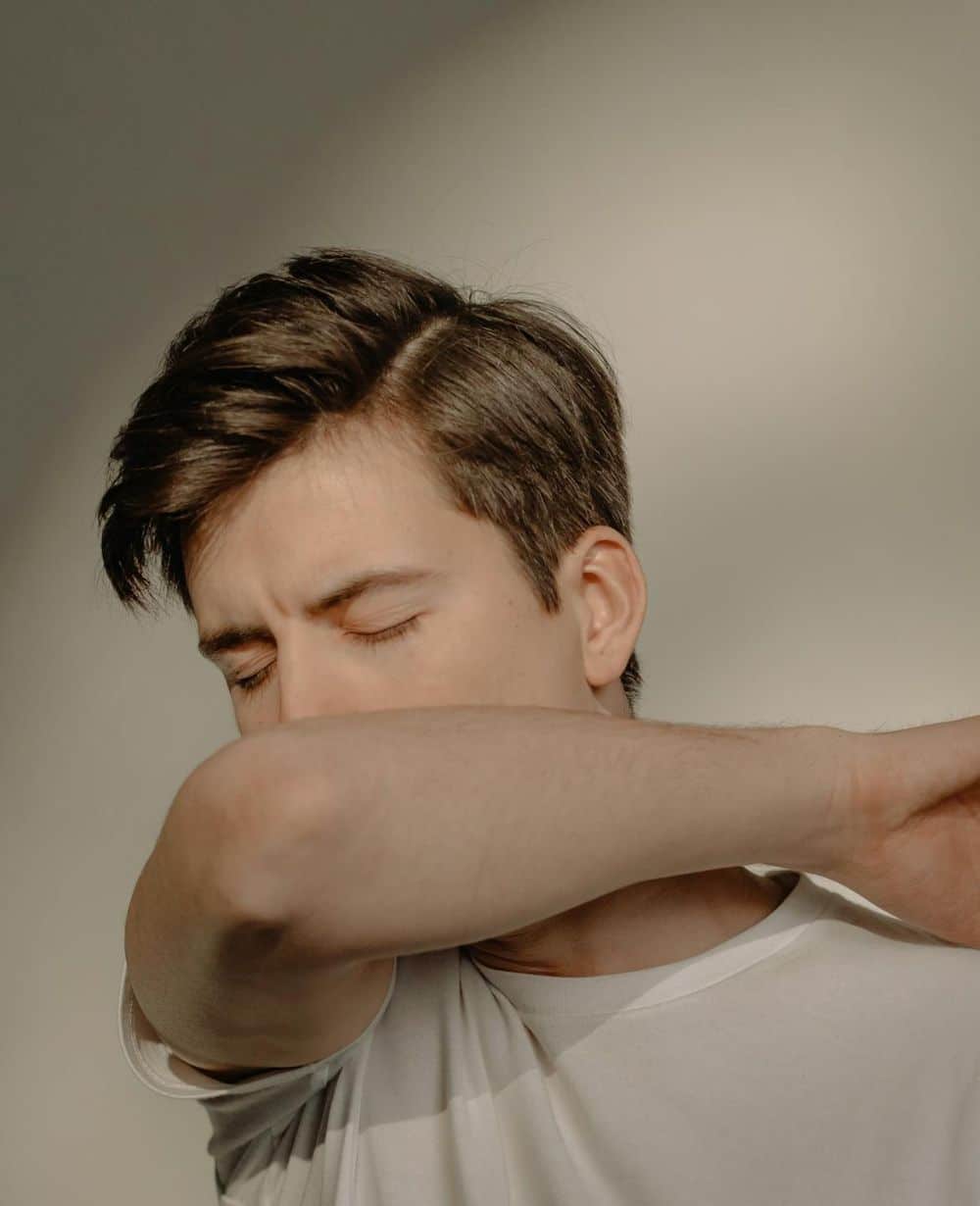 man coughing into elbow image